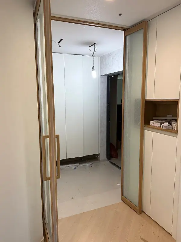 문을 열어 신발장과 현관이 보이는 우드 프레임 스윙도어