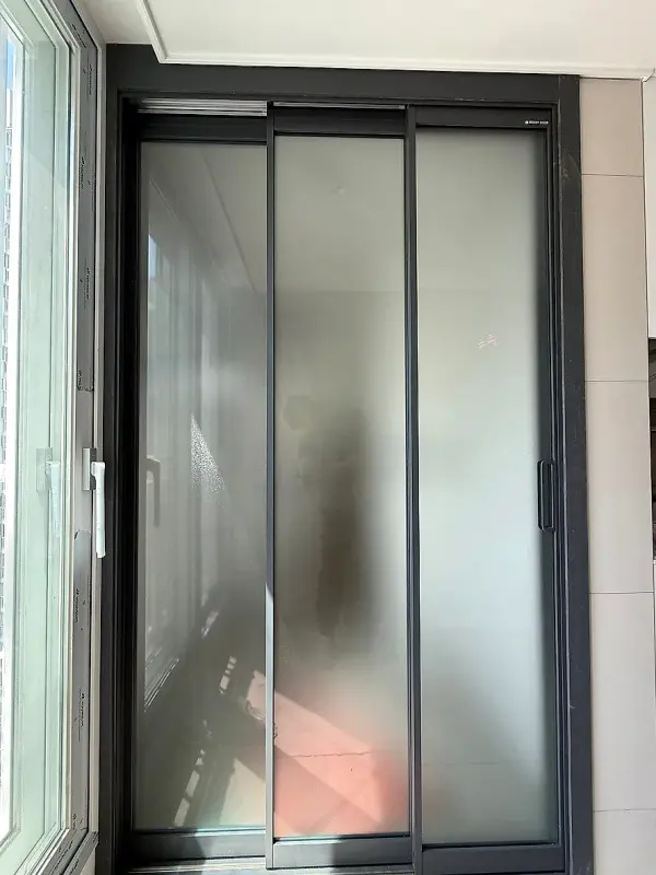 미스트유리가 들어간 다크그레이 3연동이 닫혀 있는 다용도실 입구
