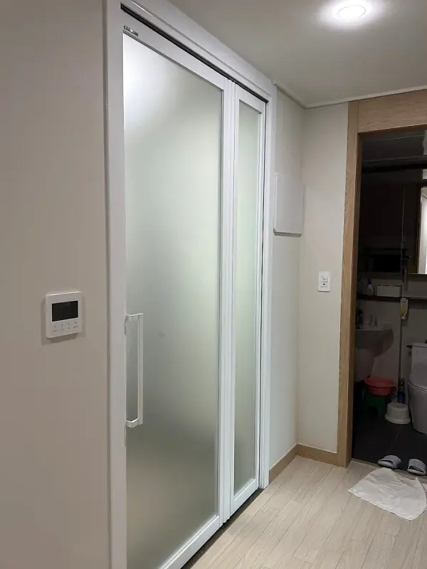 실내 쪽에서 본 백사틴유리 문짝과 벽을 함께 덮은 몰딩