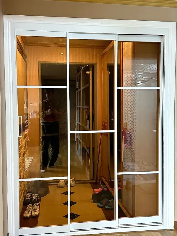 흰색 격자 디자인이 들어간 브론즈 유리 문짝 근접 모습