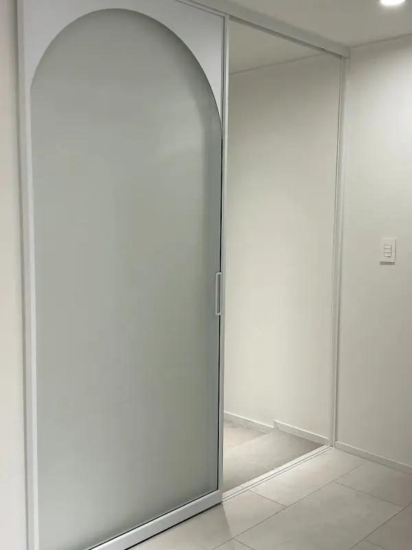 벽 쪽으로 밀려 있는 아치형 미스트유리 슬라이딩 문짝
