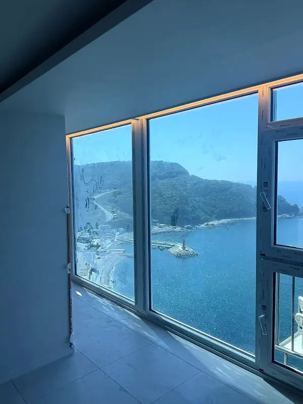 창밖으로 섬과 해안선, 바다가 펼쳐진 거실 창가