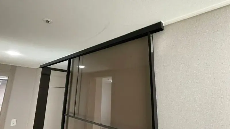 천장 아래 설치된 블랙 상부레일과 문짝 상단