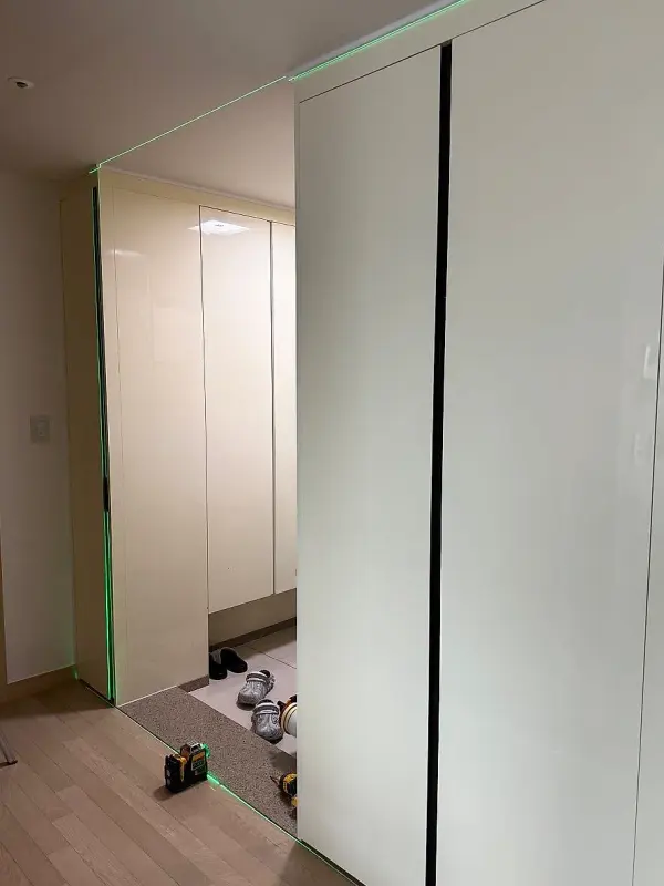 현관 수납장 옆 벽에 비친 레이저 설치선