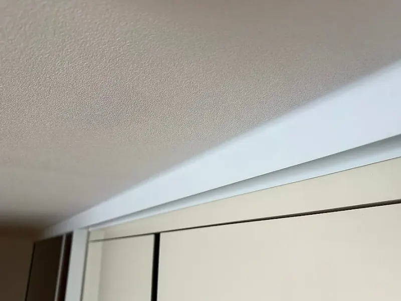 천장과 맞닿은 화이트 상부레일의 실리콘 마감