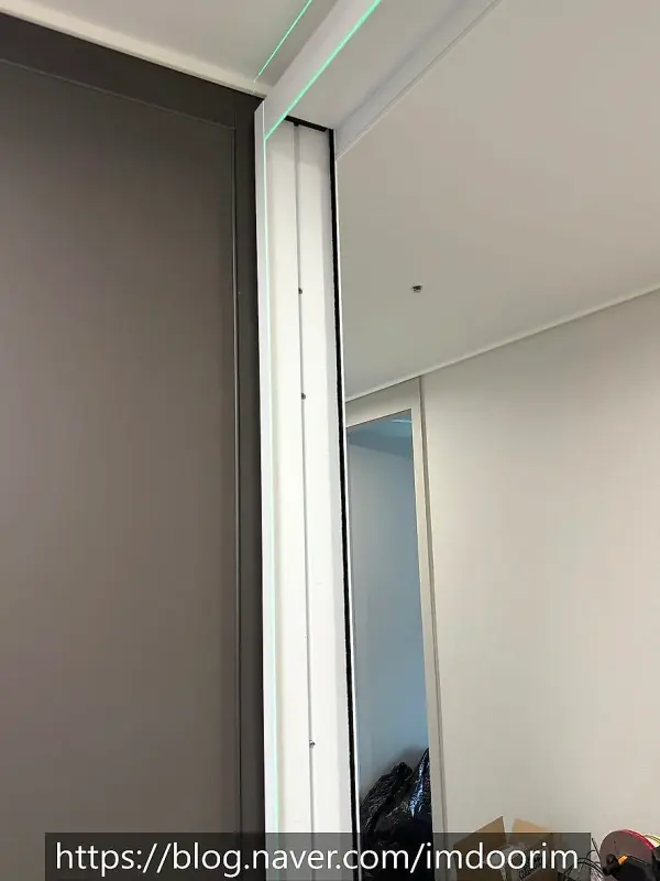 현관 개구부 벽면에 세운 흰색 3연동 문틀 근접 모습