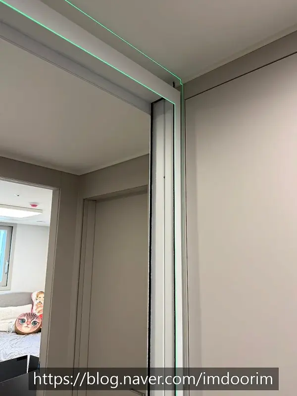 현관 개구부에 고정된 문틀 상단과 측면 프레임