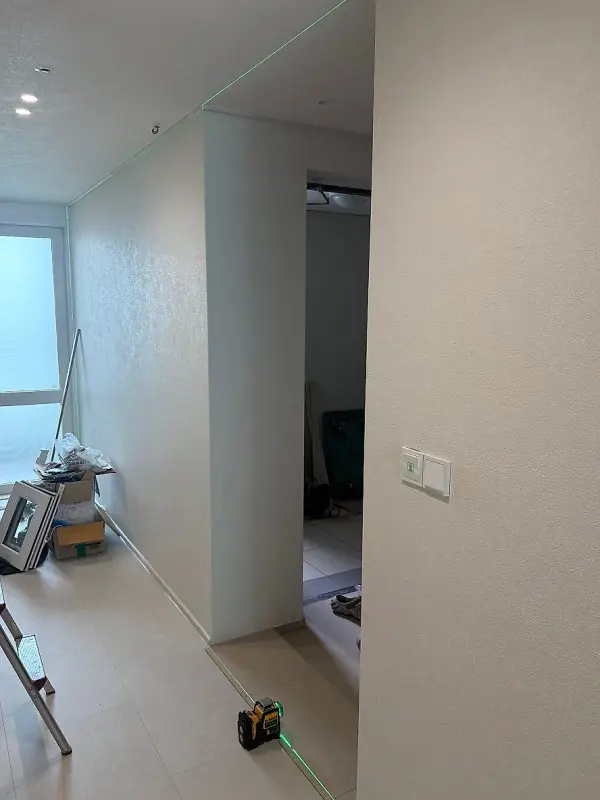 중문 설치 전 현관 통로에 공구와 레이저 장비가 놓인 모습