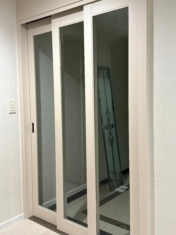 새 투명유리를 끼운 문짝과 벽에 기대어 둔 유리