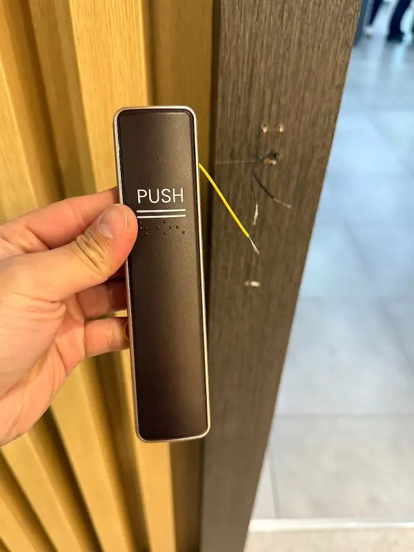 노란색 선 두 가닥이 나온 새 PUSH 터치 스위치를 손에 든 모습