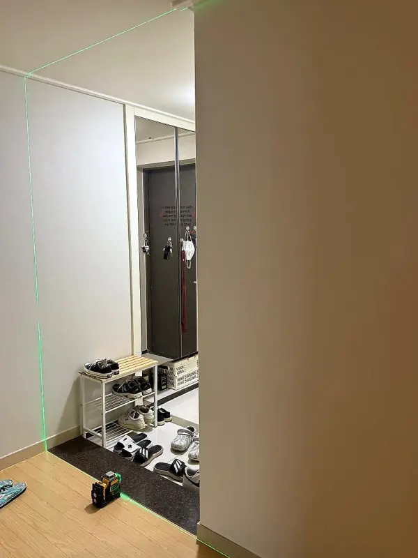 레이저 기준선이 비친 중문 설치 전 현관과 신발장