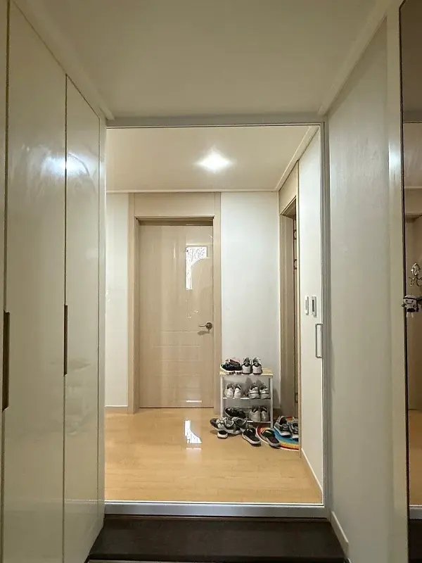 실내 쪽에서 열린 중문 너머로 보이는 현관