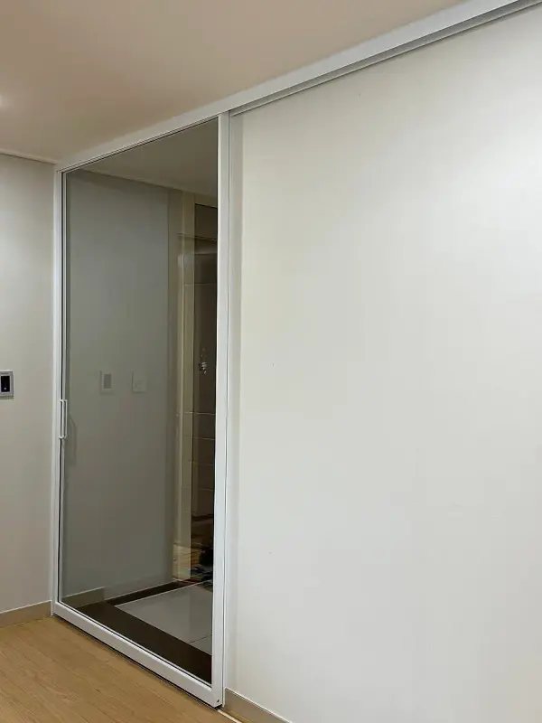 현관 쪽에서 본 투명유리 슬라이딩 도어와 몰딩 마감