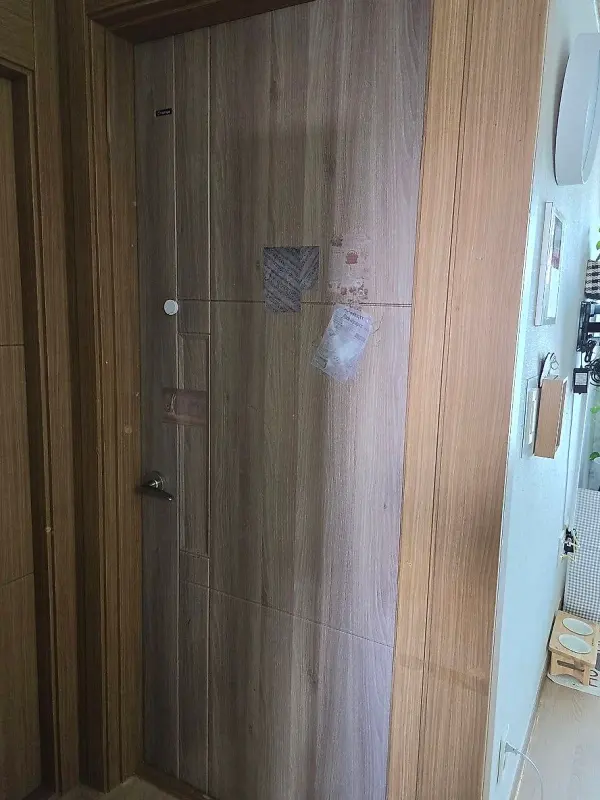 긁힘과 필름 들뜸이 남아 있는 어두운 우드톤 기존 방문