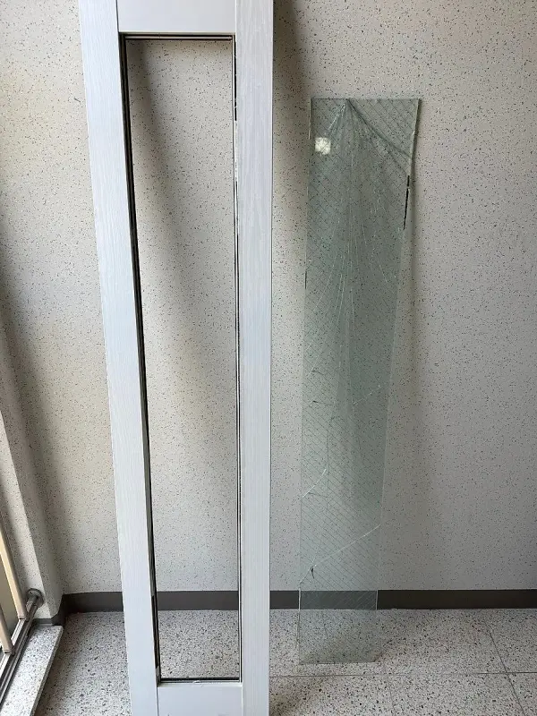 파손 유리를 빼내 비어 있는 중문 문짝 프레임