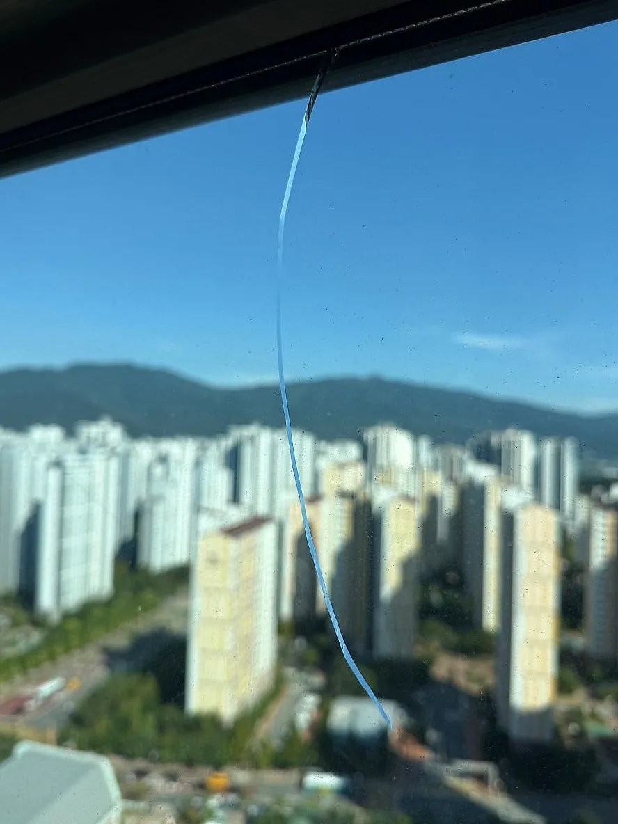 고정창 유리를 위에서 아래로 가로지르는 긴 균열