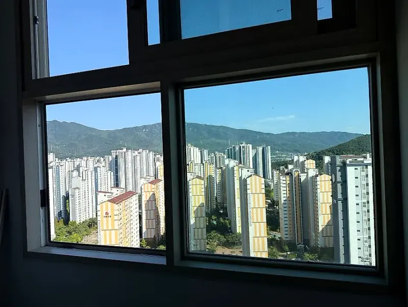 새 유리로 교체한 작은방 창 너머로 보이는 아파트 단지