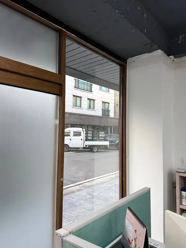 매장 안쪽에서 바라본 교체된 유리와 바깥 거리 풍경
