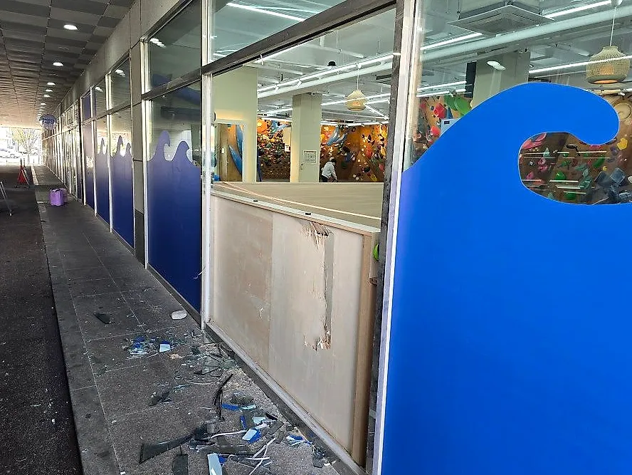 상가 앞 바닥에 유리 파편이 흩어진 대형 유리 철거 작업 현장